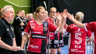 Louise Wickström, centralt i bild, står längst fram i ett långt tåg av KAIS Mora-spelare som ger varandra en high-five efter ett mål.