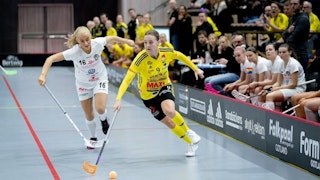 Endres Linnéa Wallgren driver bollen och jagas av Täbys Anna Peterzén. I bakgrunden till höger syns Täbybänken.